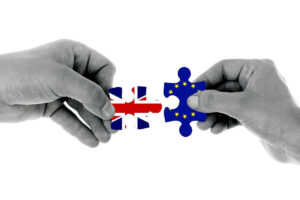 UK and EU flags on jigsaw puzzle pieces, held apart