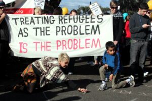 "treating refugees as the problem IS the problem" banner